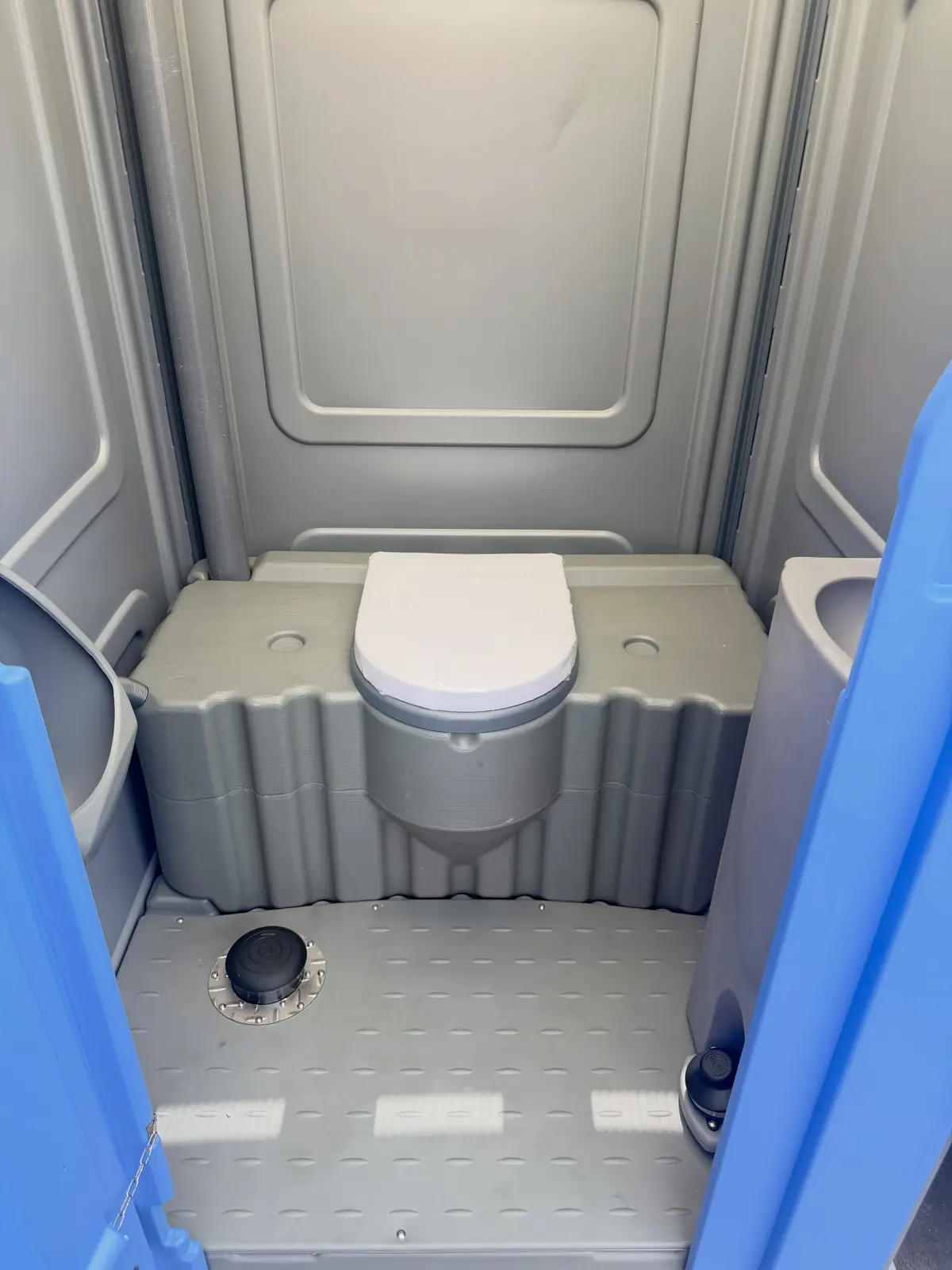 Inside a deluxe porta potty with a sink