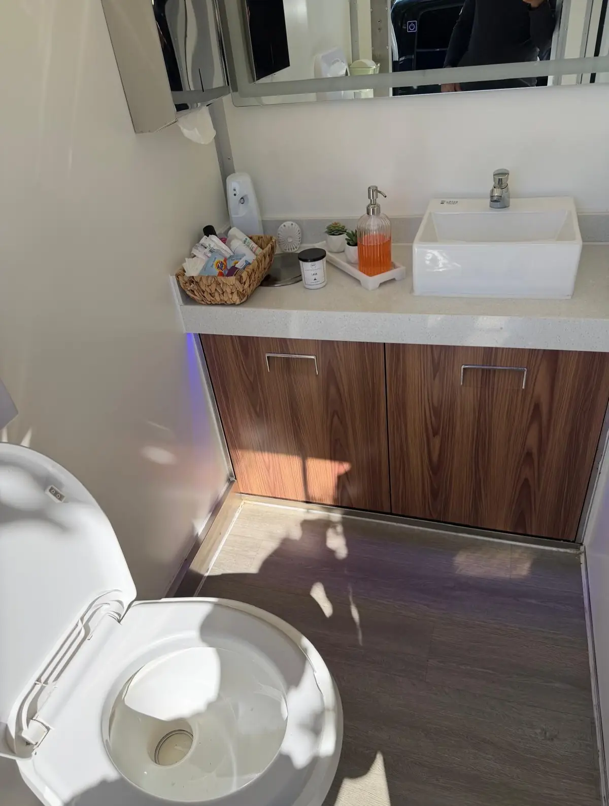 Wood vanity and sink inside a luxury restroom trailer