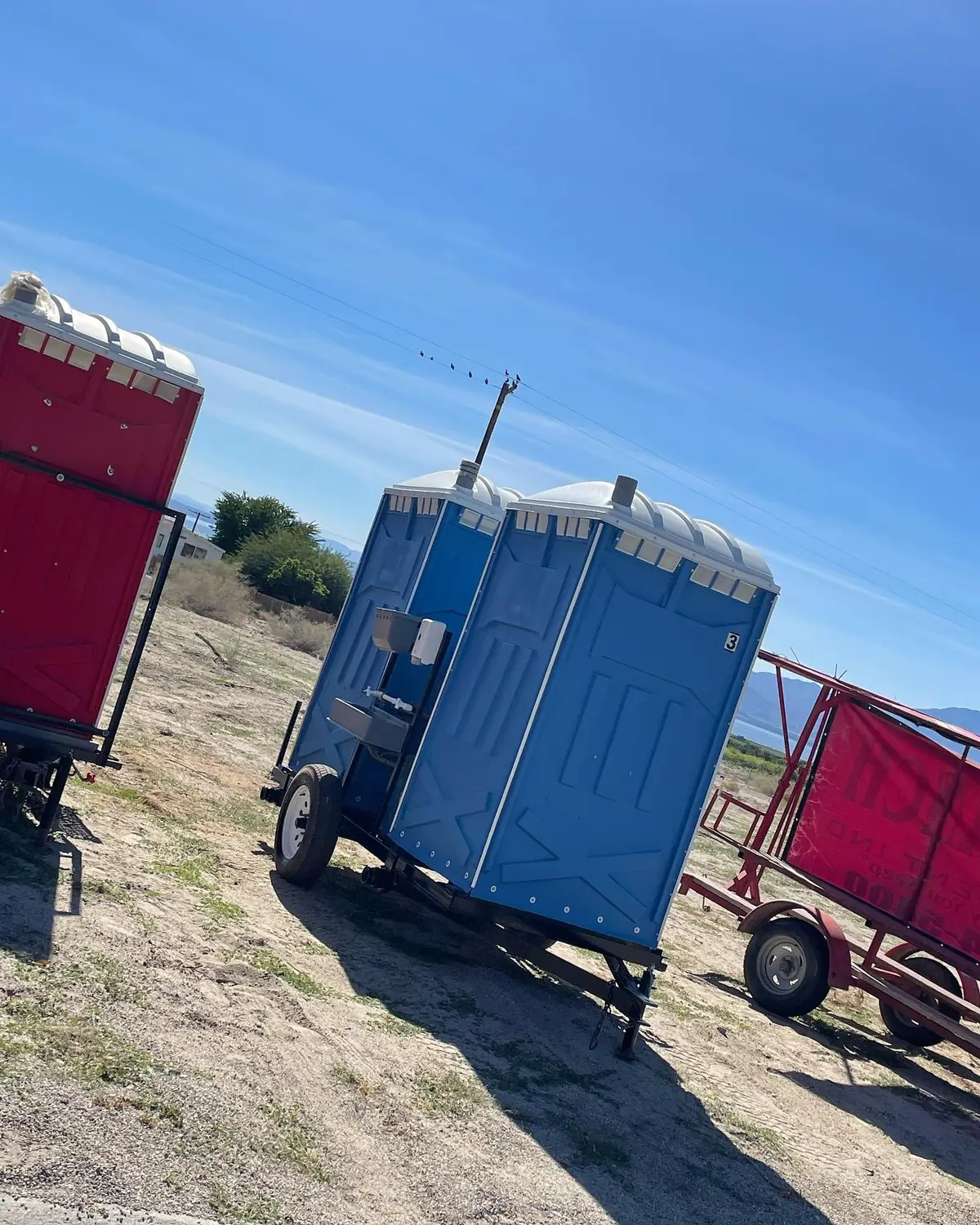 Portable toilets strapped onto tow trailers for transport