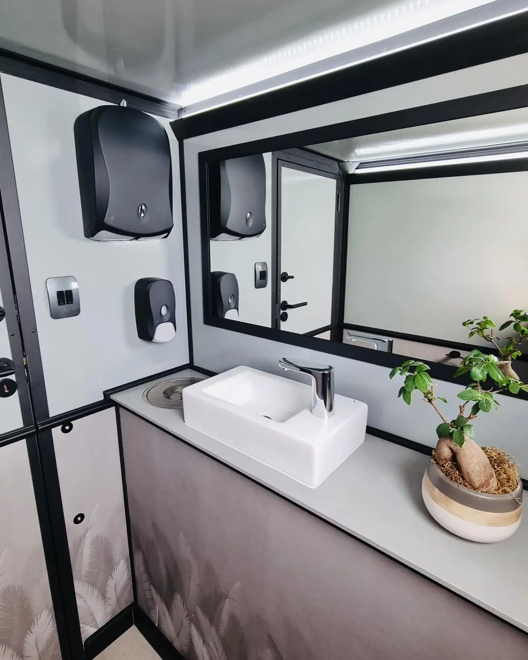 Vanity sink and mirror inside a restroom trailer
