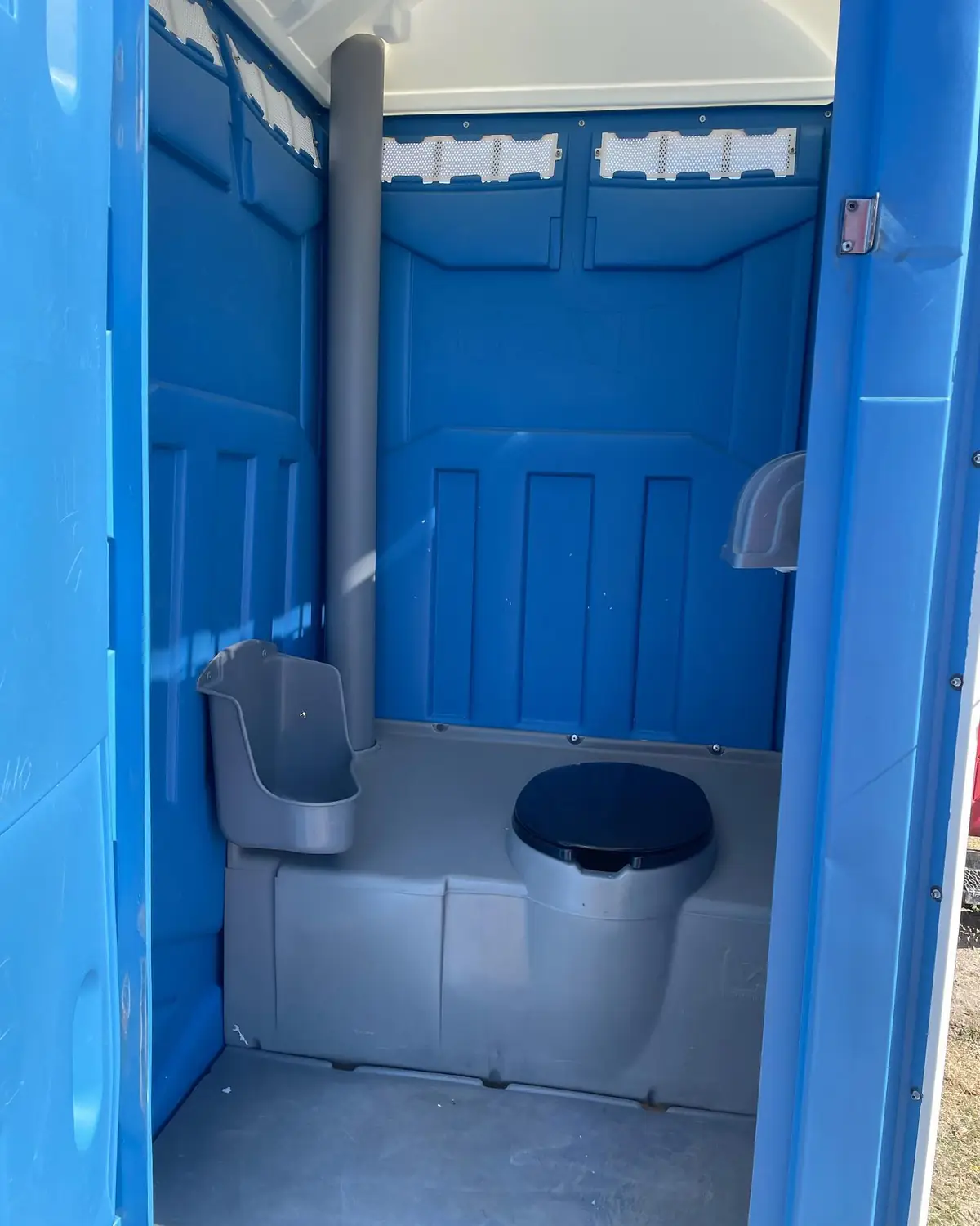 Clean inside of a standard porta potty with a stocked paper holder
