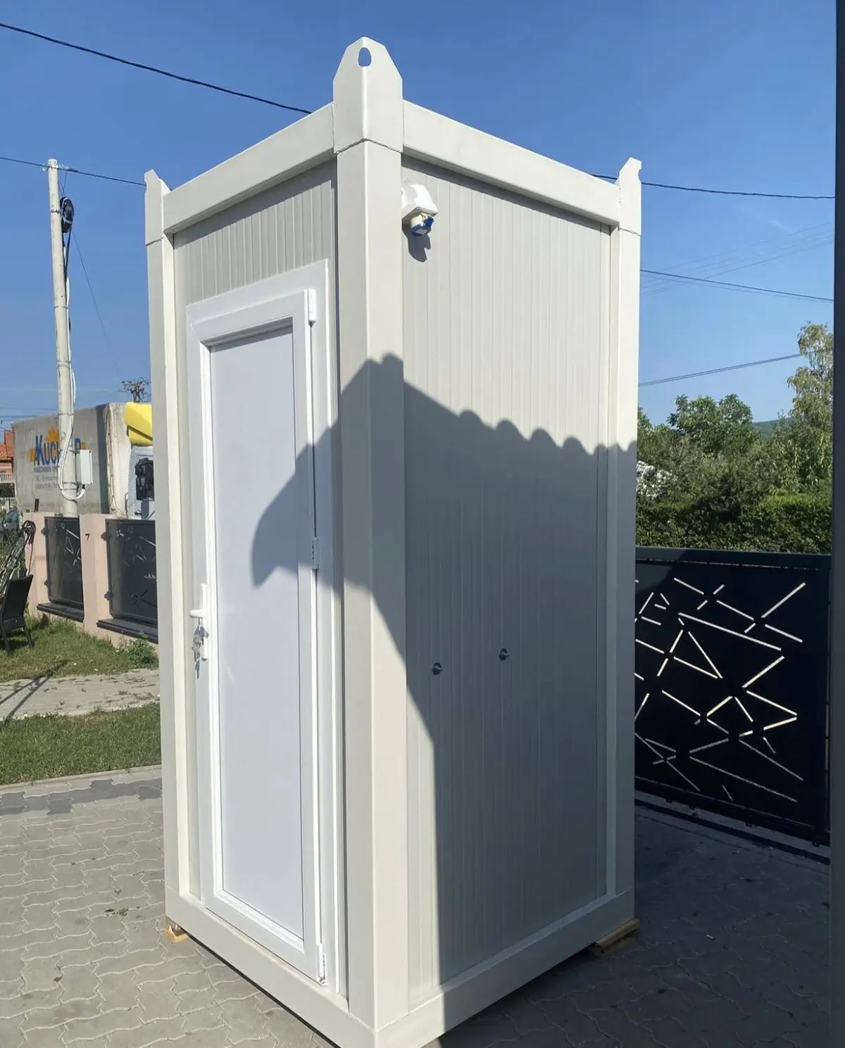 White single-room VIP restroom cabin set on paver stones