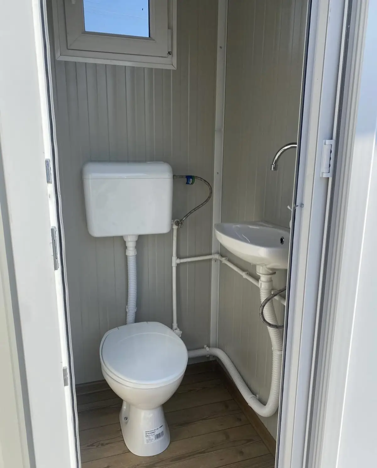 Inside a single-room VIP restroom cabin with toilet and vanity